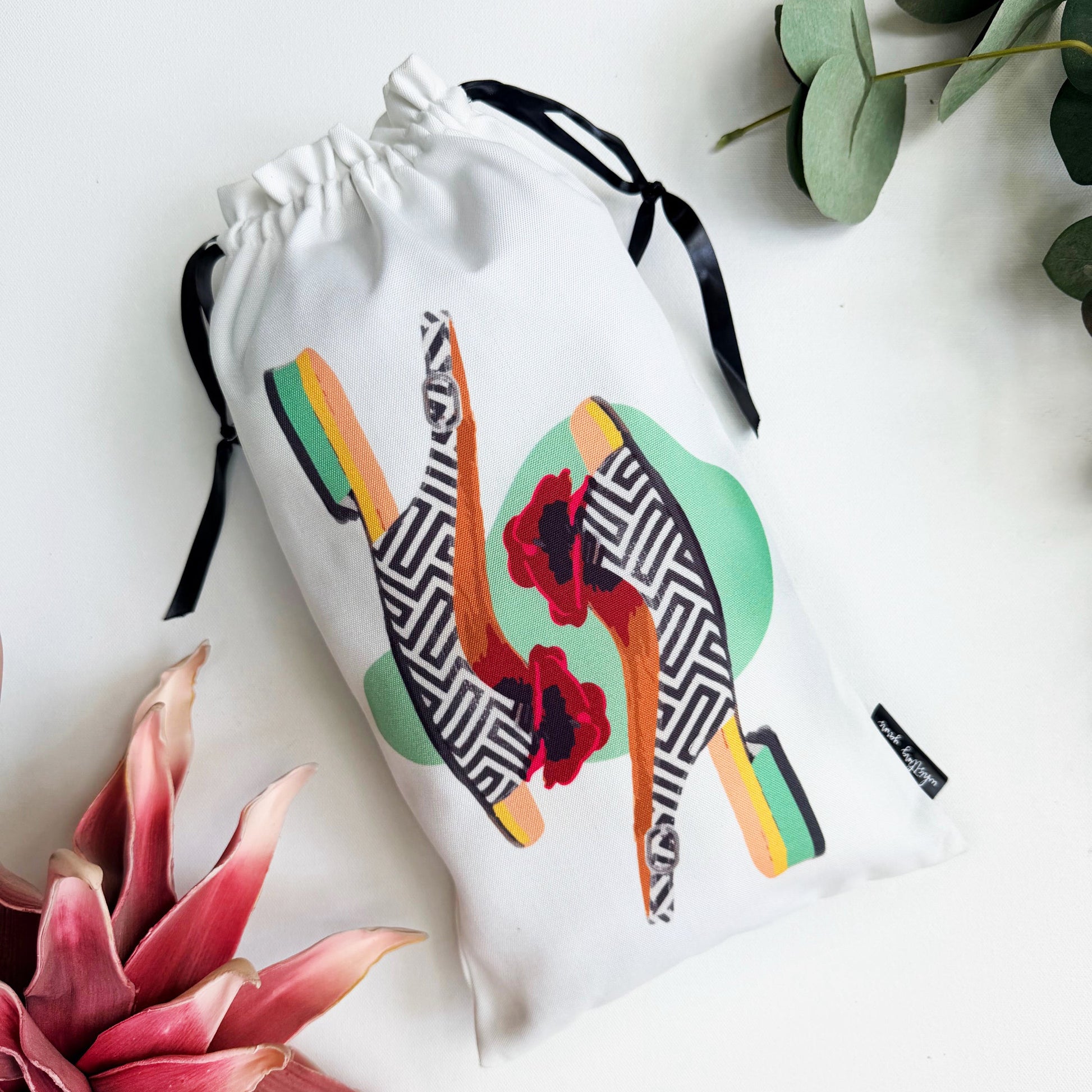 Shoe bag with colorful vibrant ballet flat design on a white background.