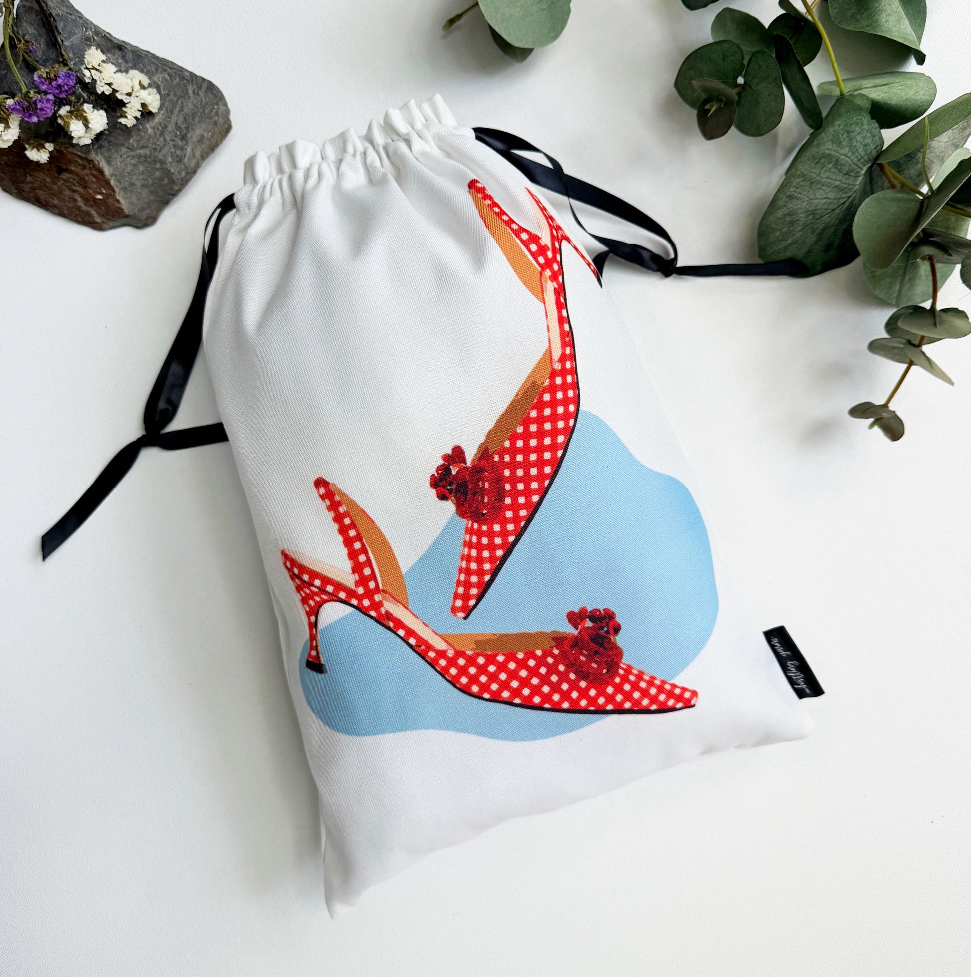 Shoe bag with red polka dot kitten heels design on a white background.